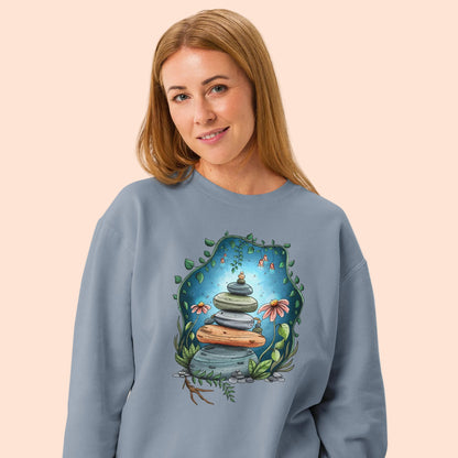 Product mockup of Cosmic Cairn Sweatshirt.  Denim blue sweatshirt with an illustrated rock stock on top. 